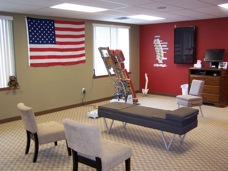 Liberty Chiropractic adjusting room with a large American flag and red accent wall, Sioux Falls